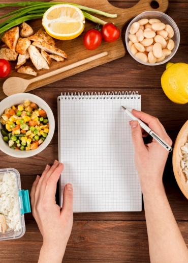 hands-writing-notebook-with-casseroles-ad-food_23-2148487771